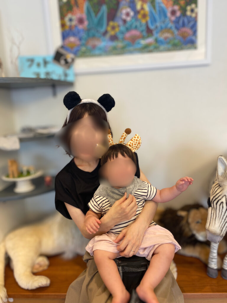 店内のフォトスポットで動物カチューシャをつけた母子の記念写真