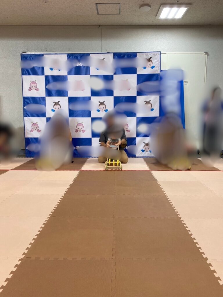 スタートラインに並んだ子どもと保護者がカタカタを持ち順番を待つ場面