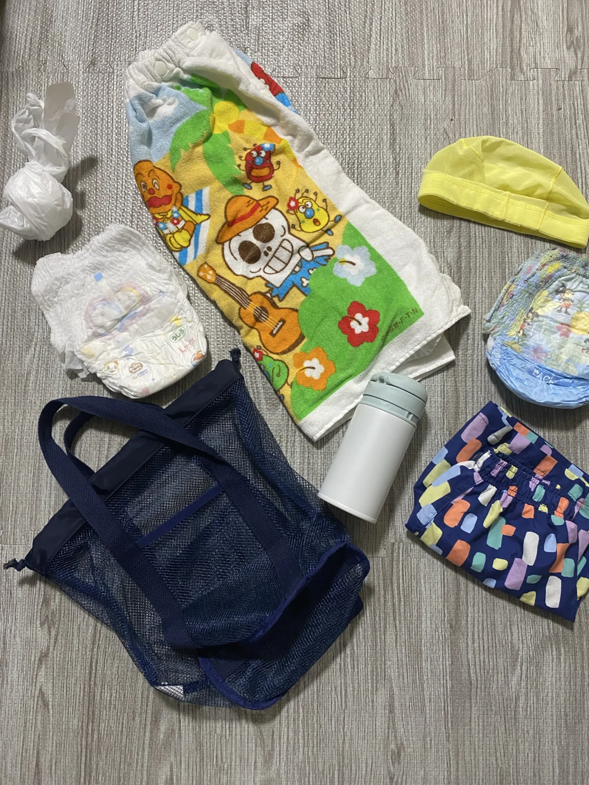 1歳児のベビースイミング持ち物一式。水着、水遊び用おむつ、スイムキャップ、巻きタオル、着替え用おむつ、水筒、濡れたものを入れる袋